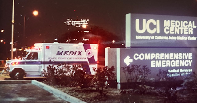 A Medix Neonatal Intensive Care Transportation ambulance at night, emergency lights active, parked outside UCI Medical Center in Irvine, California