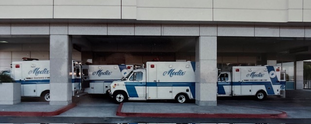 Three Medix ambulances lined up side by side inside a covered hospital bay, ready for dispatch